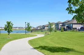 a walking path alongside a man made lake in a newer high-end neighbourhood