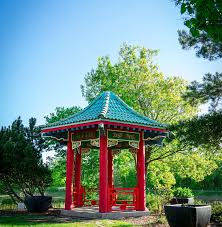 a red chinese pagoda surrounded by greenspace